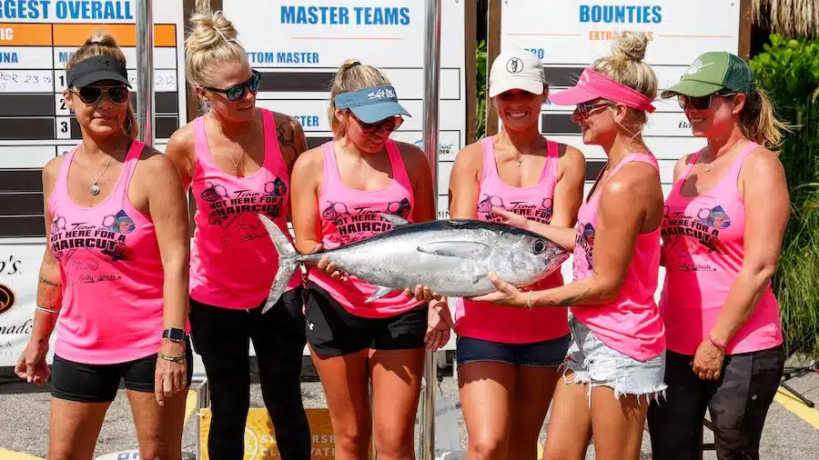 The Not Here For A Haircut team holds a blackfin tuna they caught for competition during the Suncoast Ladies’ Classic at Tiki Docks Skyway Bar and Grill on July 13 in St. Petersburg. [ JEFFEREE WOO | Times ]